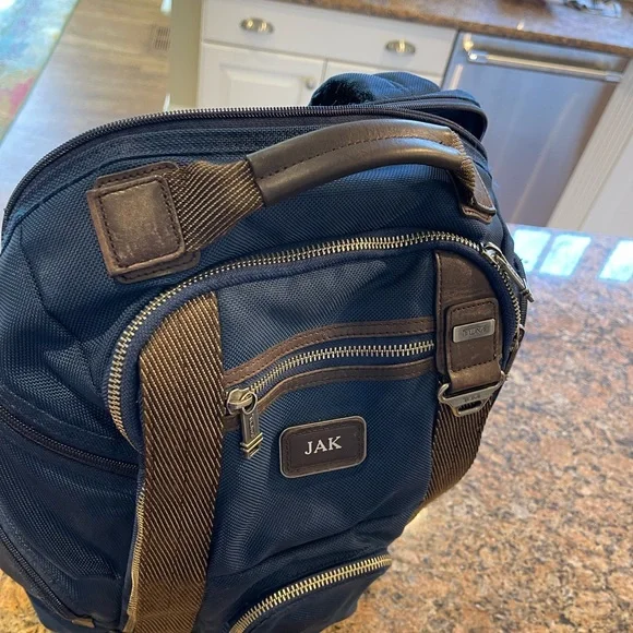 Tumi blue and black backpack. All zips & interior excellent. Two small spots.